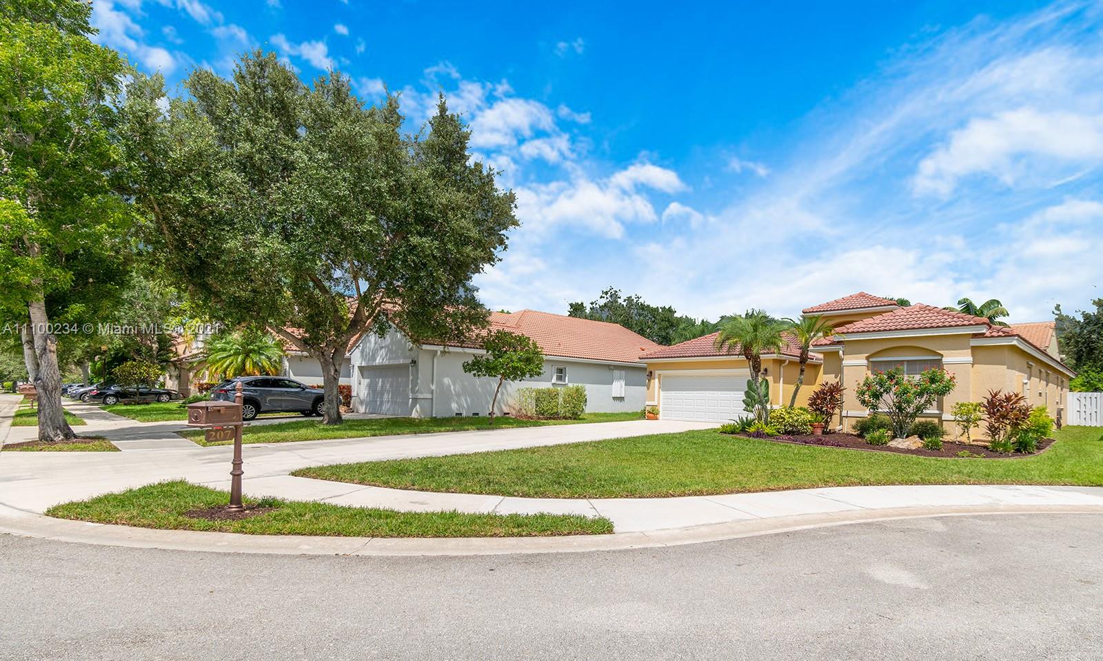 207 Cameron Court Weston, FL 33326 - Photo 4 of 35 a view of a house with a big yard plants and trees