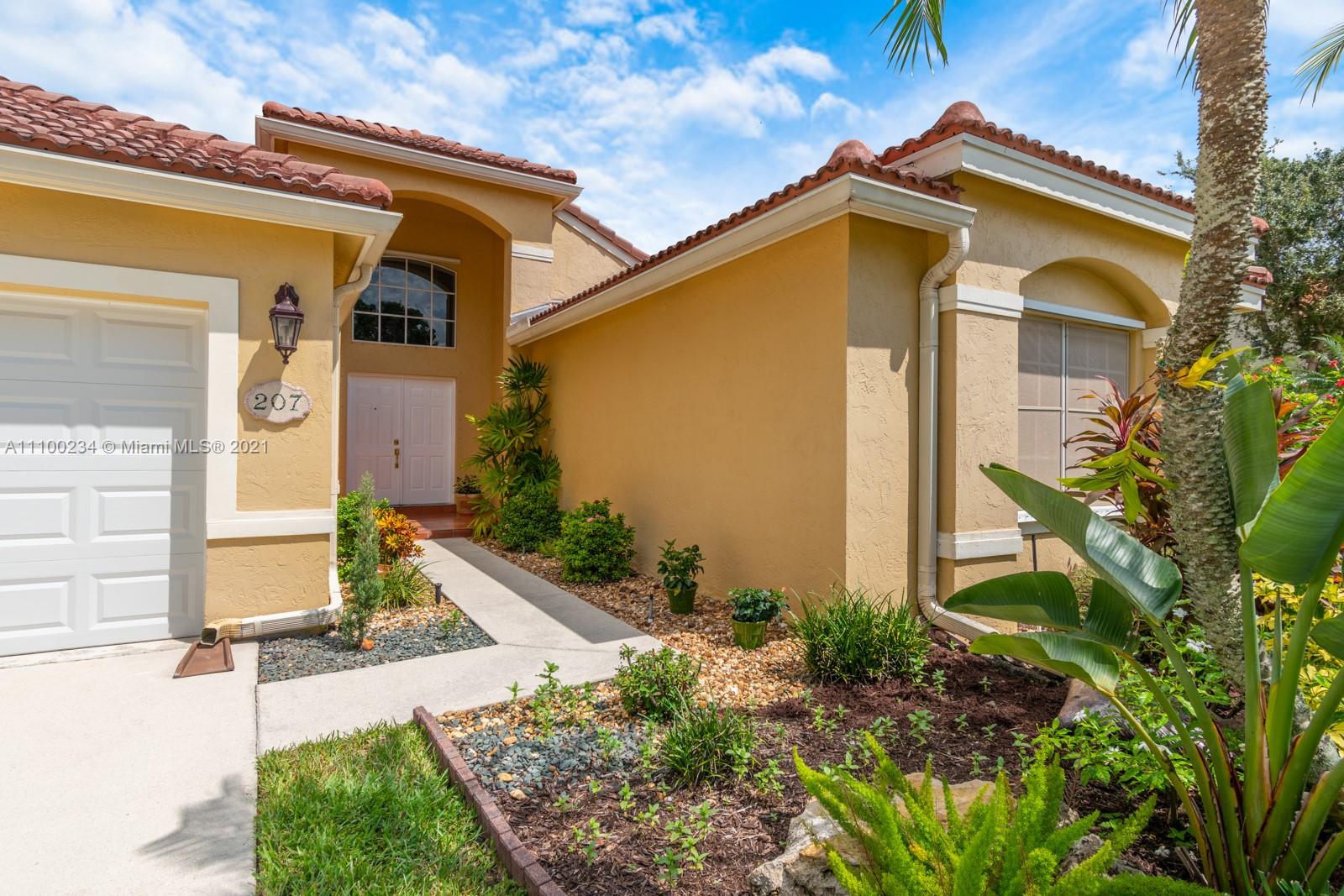 207 Cameron Court Weston, FL 33326 - Photo 5 of 35 a front view of a house with garden