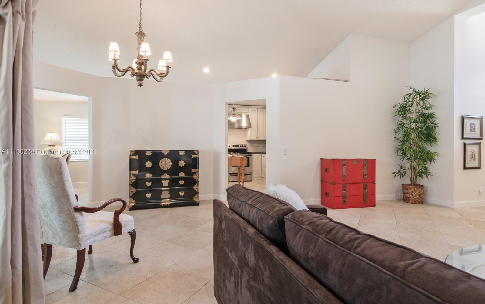 207 Cameron Court Weston, FL 33326 - Photo 9 of 35 a bedroom with a bed dresser and a chandelier