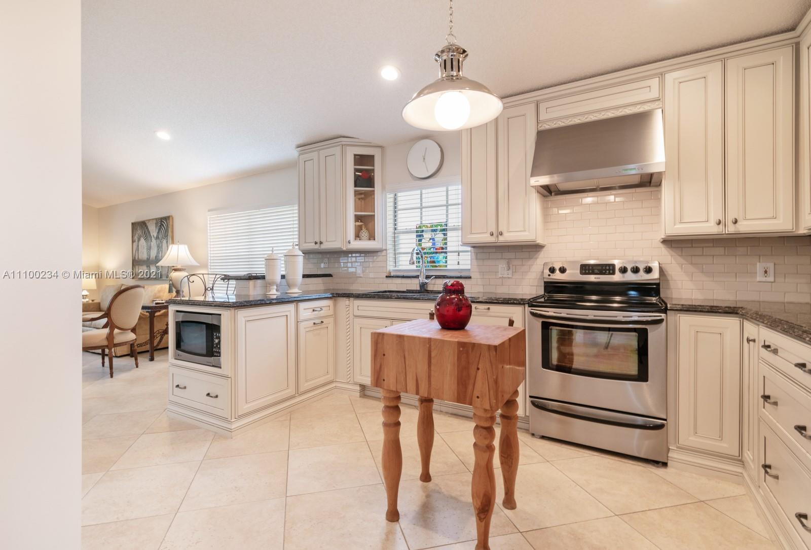 207 Cameron Court Weston, FL 33326 - Photo 10 of 35 a kitchen with granite countertop white cabinets and white appliances