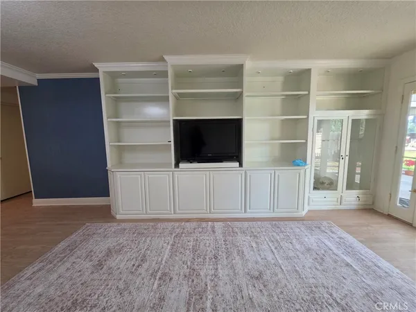 a view of a livingroom with an empty space & wooden floor