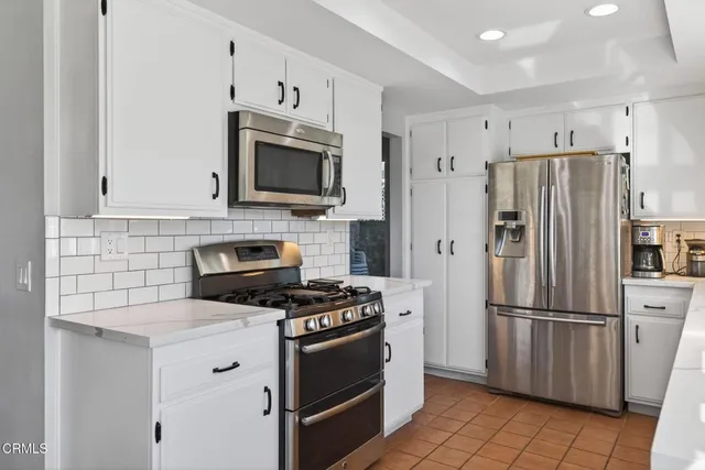 a kitchen with cabinets stainless steel appliances and a counter space