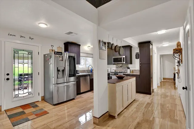 a kitchen with stainless steel appliances kitchen island granite countertop a refrigerator and a stove