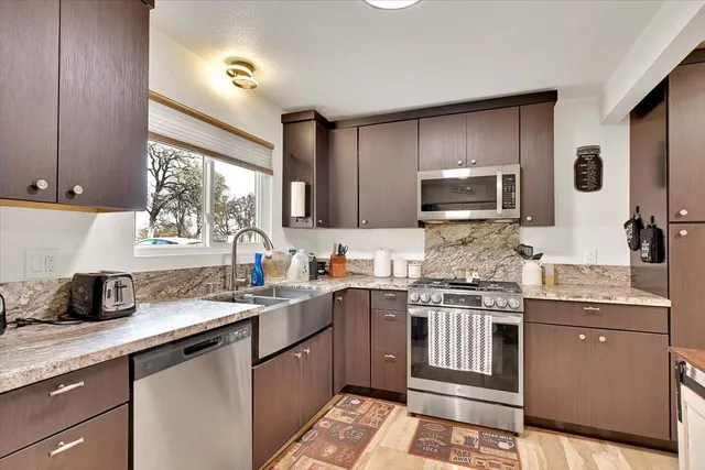 a kitchen with stainless steel appliances granite countertop a sink stove and microwave