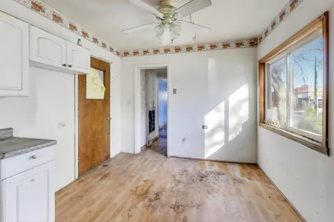 a view of a hallway with a dining space cabinetry and windows