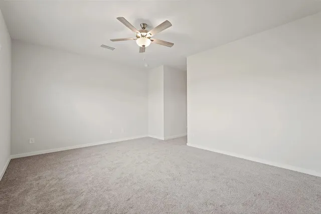 an empty room with a chandelier fan