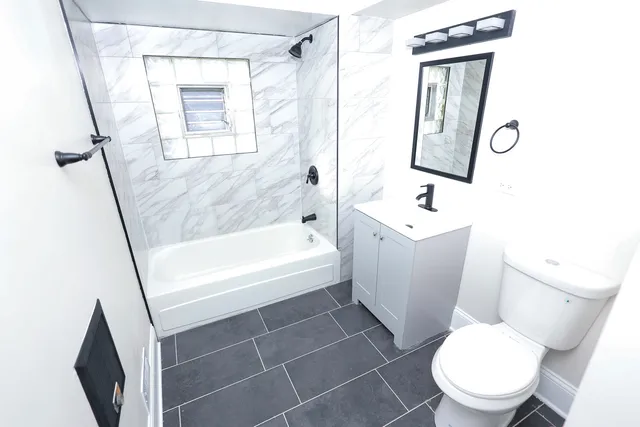 a white toilet sitting next to a bathroom sink