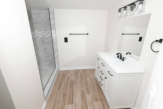 a bathroom with a sink a mirror and a shower