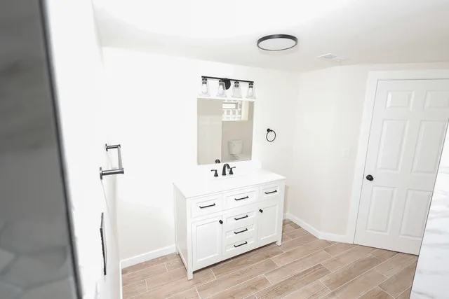 a bathroom with a bathtub sink and mirror