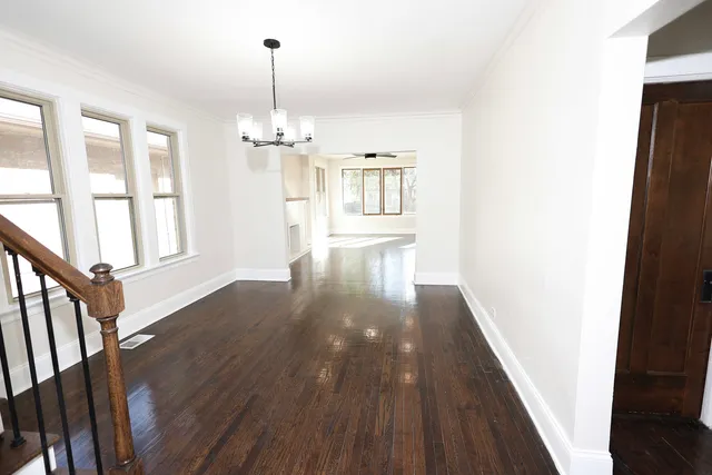 a view of a hallway with wooden floor and staircase