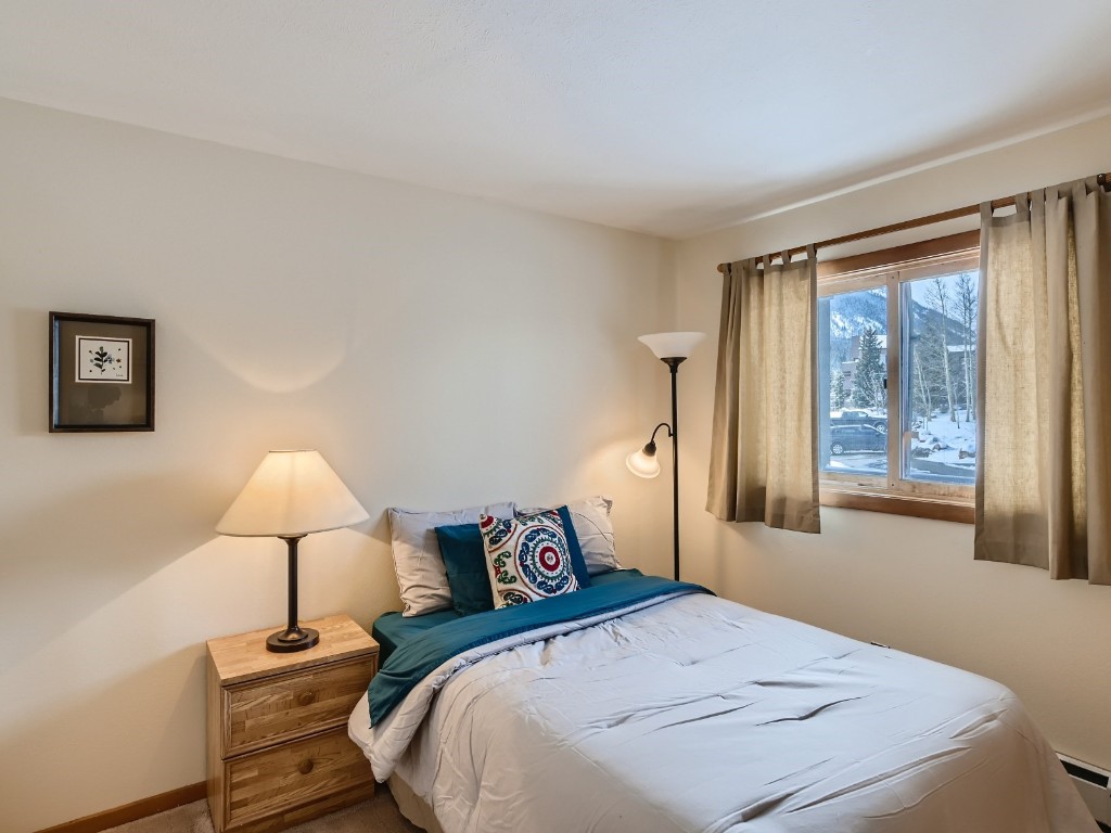 94300 Ryan Gulch Road, Unit 94402 Silverthorne, CO 80498 - Photo 15 of 27 a bedroom with a bed and a window
