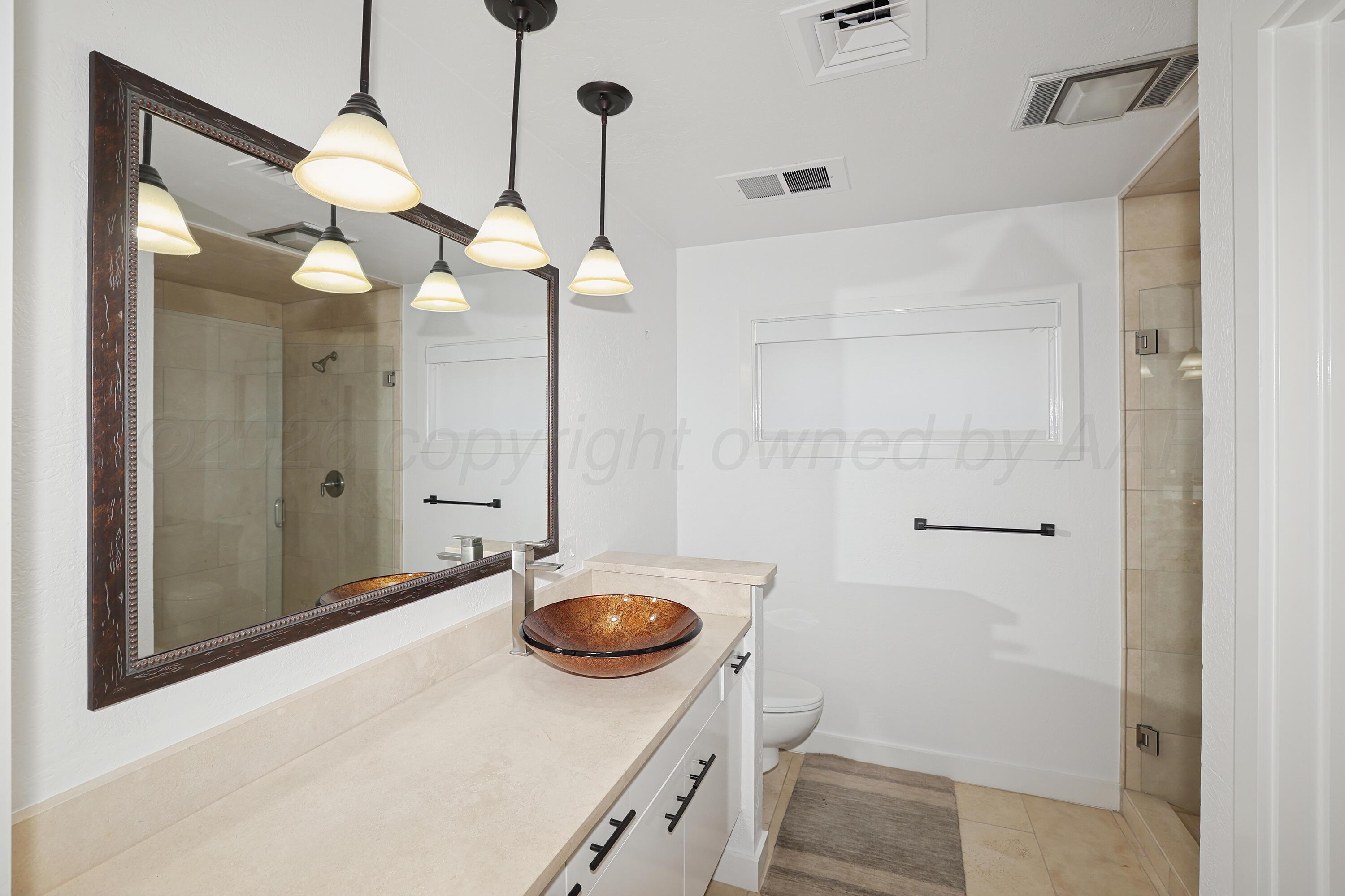2 Woodstone Street Amarillo, TX 79106 - Photo 25 of 34 a bathroom with a sink a light fixture and a mirror