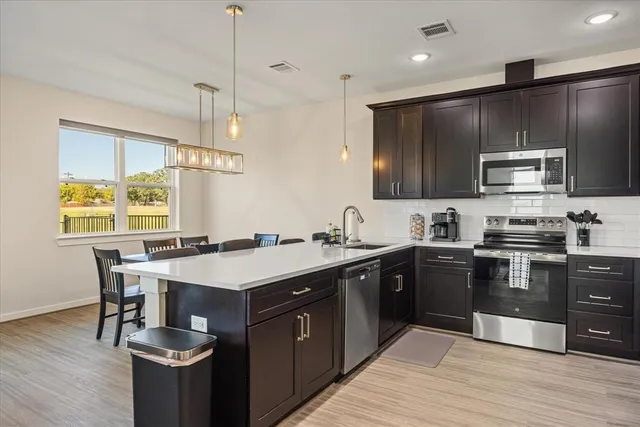 a kitchen with kitchen island granite countertop stainless steel appliances and sink