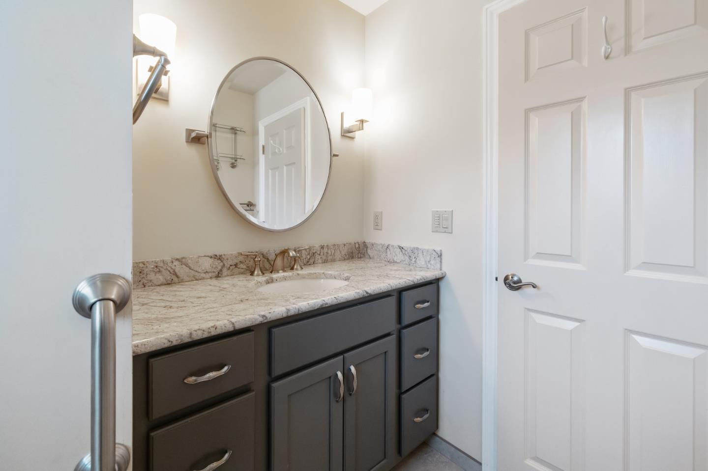 708 Johnston Street Half Moon Bay, CA 94019 - Photo 24 of 41 a bathroom with a granite countertop sink and a mirror