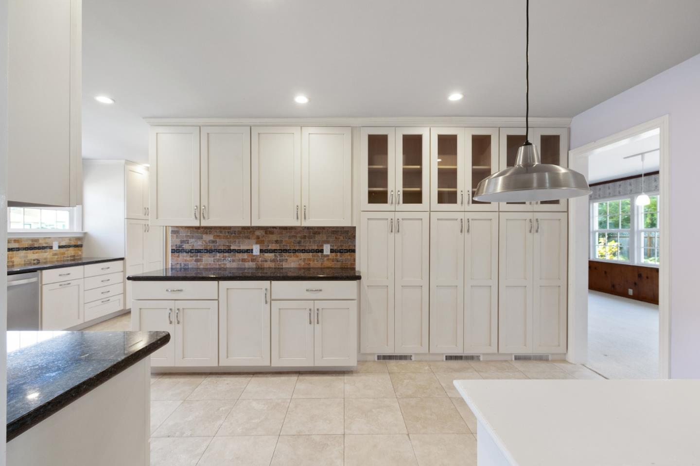 708 Johnston Street Half Moon Bay, CA 94019 - Photo 10 of 41 a kitchen with granite countertop white cabinets and white appliances