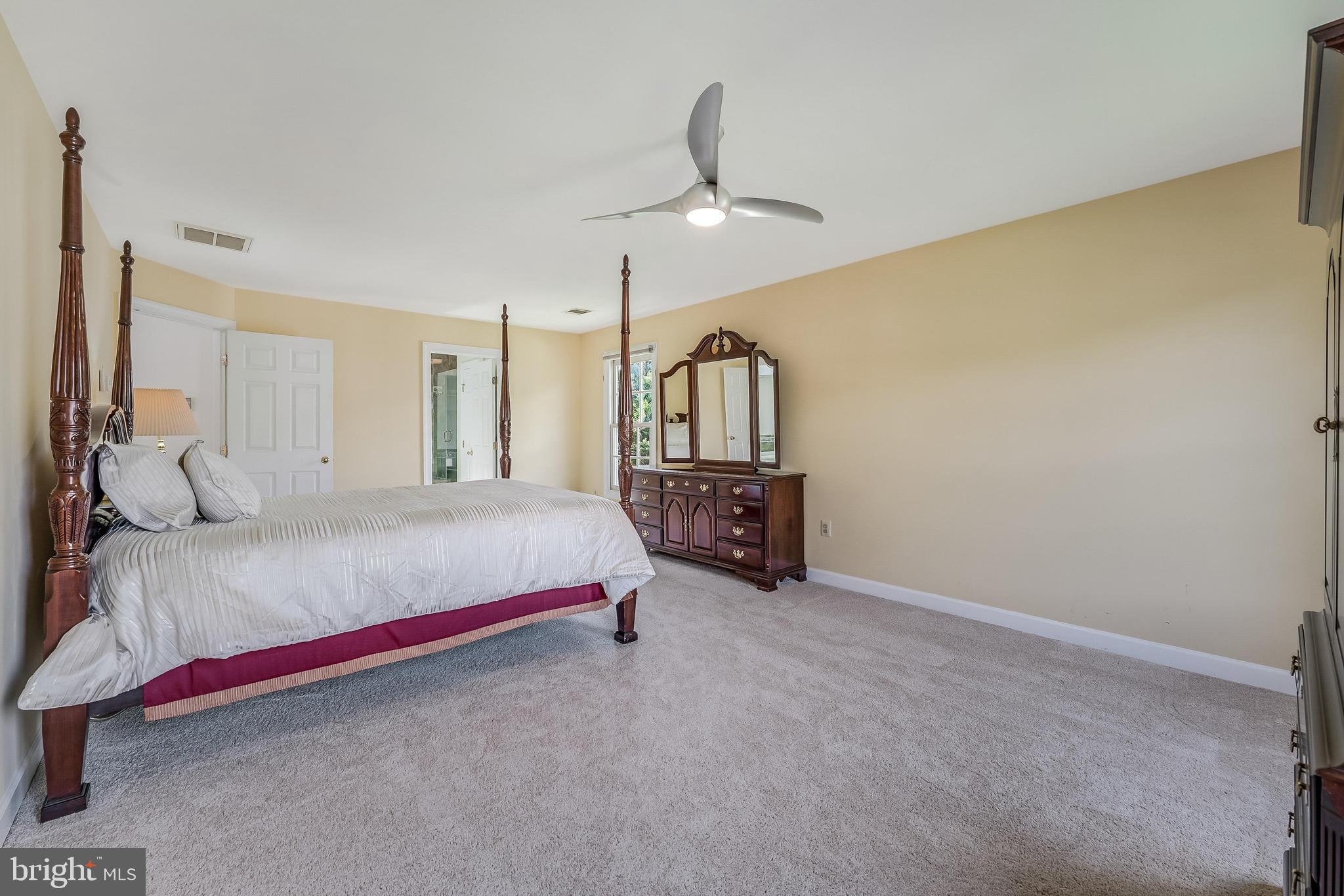 5501 Ashleigh Road Fairfax, VA 22030 - Photo 45 of 77 a spacious bedroom with a bed chandelier and a view of bathroom
