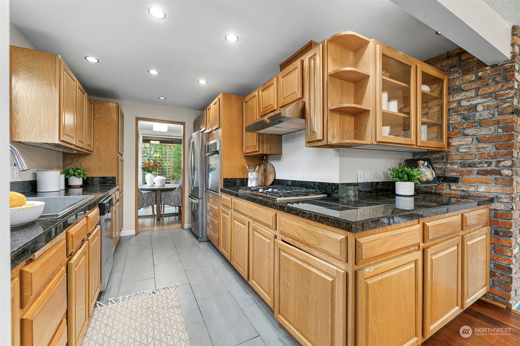 16611 Southeast 147th Street Renton, WA 98059 - Photo 7 of 32 a kitchen with stainless steel appliances granite countertop a stove a sink and a refrigerator