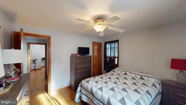 an empty room with chandelier fan and windows