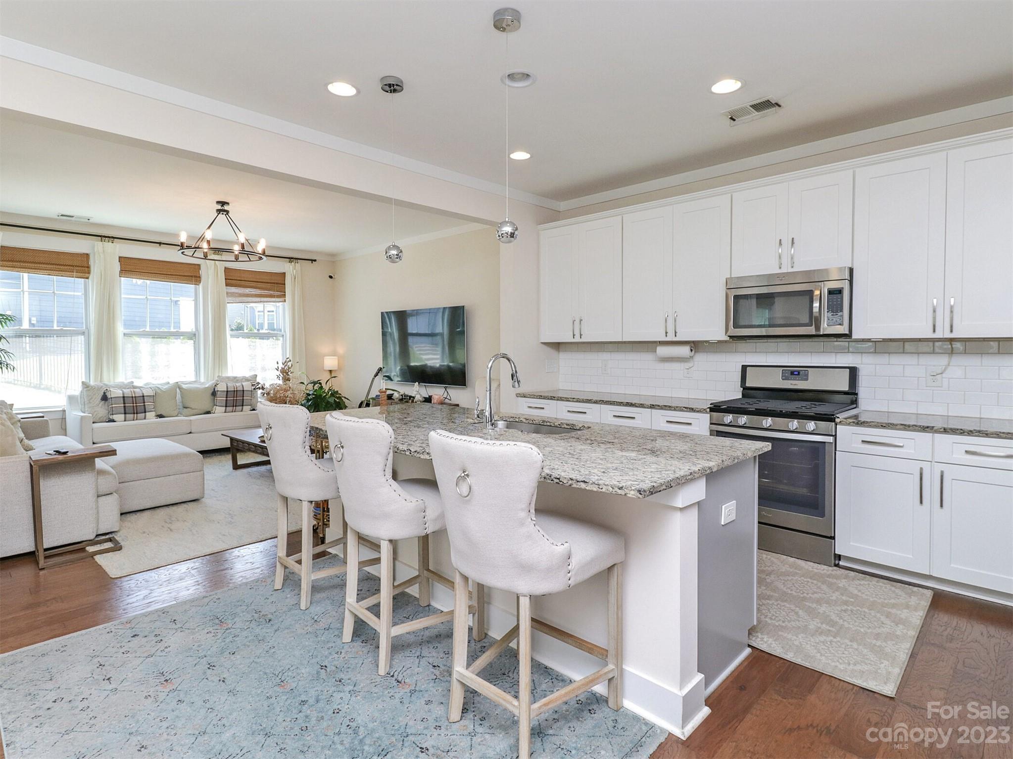 2634 Double Oaks Road Charlotte, NC 28206 - Photo 14 of 48 a kitchen with stainless steel appliances granite countertop a stove a sink dishwasher a dining table and chairs with wooden floor