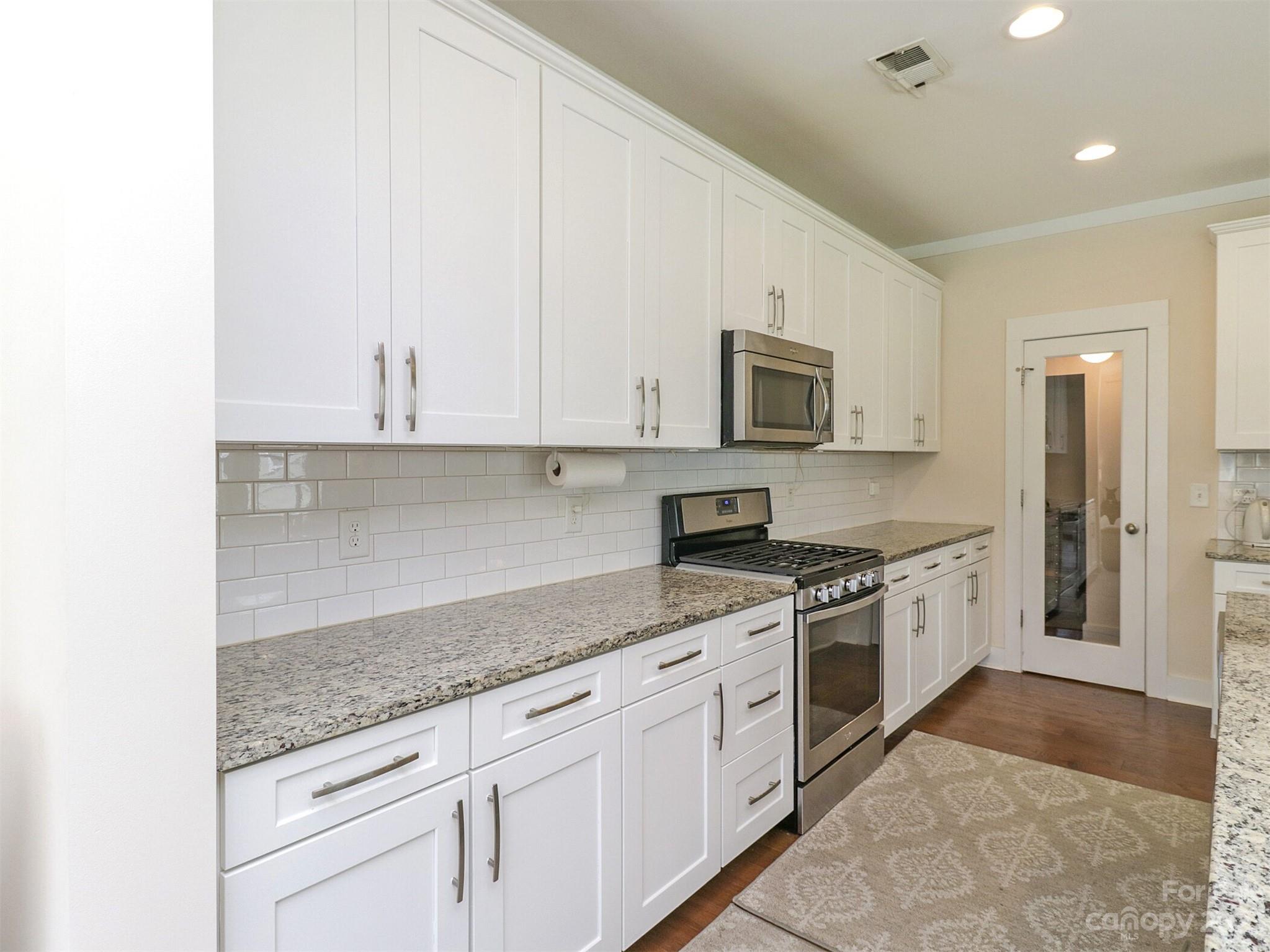 2634 Double Oaks Road Charlotte, NC 28206 - Photo 19 of 48 a kitchen with granite countertop white cabinets and stainless steel appliances