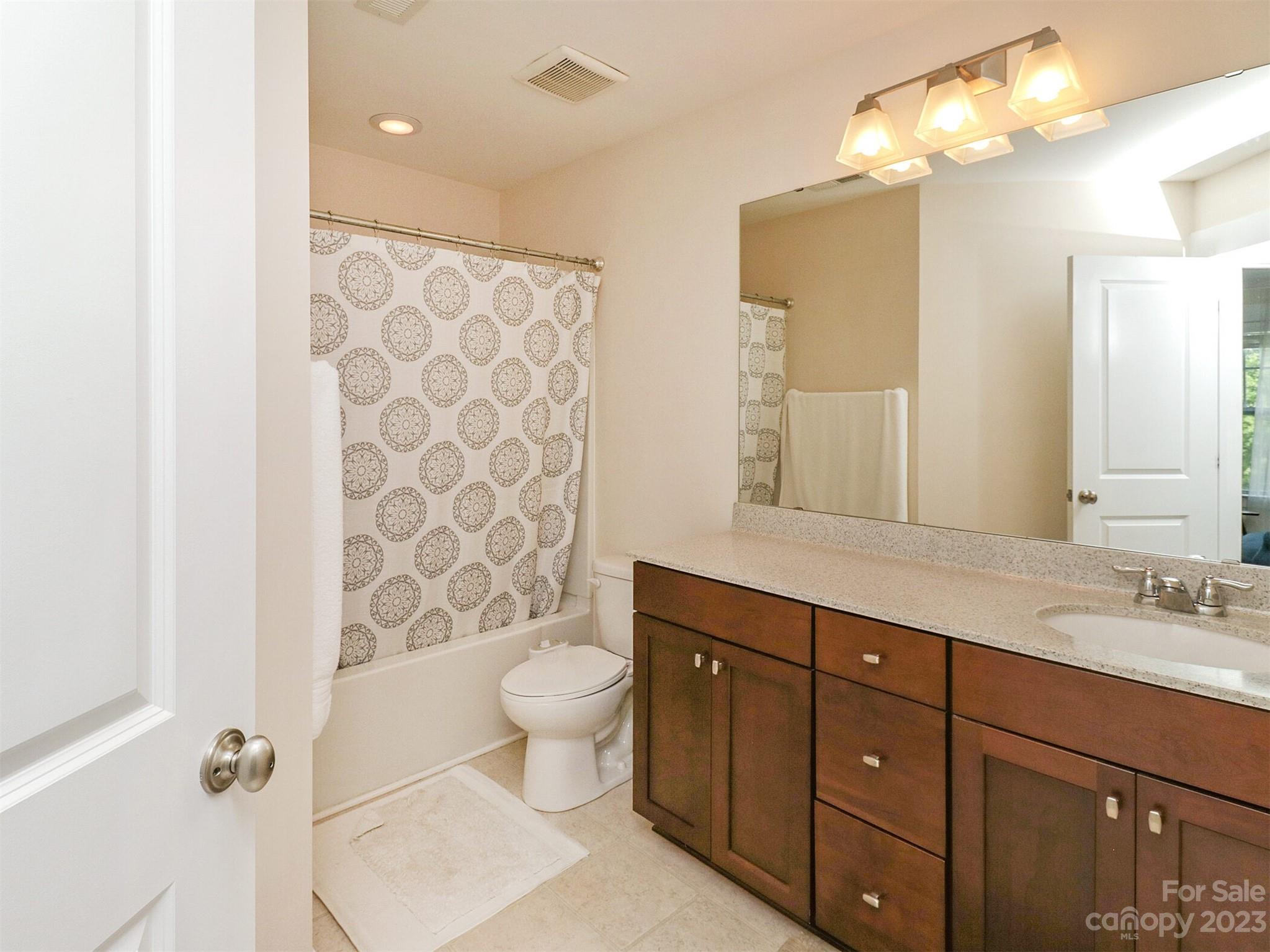 2634 Double Oaks Road Charlotte, NC 28206 - Photo 32 of 48 a spacious bathroom with a double vanity sink toilet mirror and shower