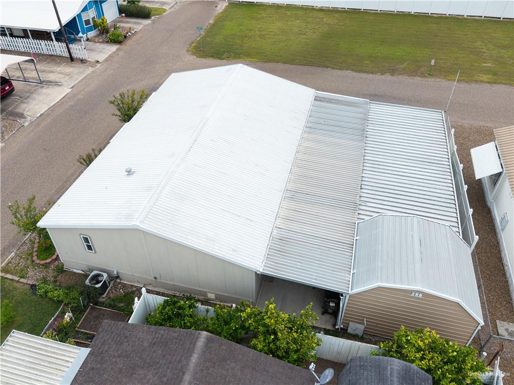 215 South Valley View Road, Unit 252 Donna, TX 78537 - Photo 17 of 19 Property featuring a metal roof, an extended covered carport, and an air conditioning unit