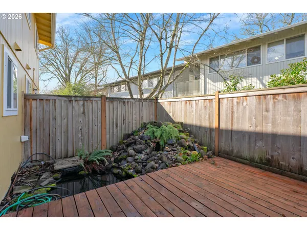 a view of backyard with potted plants and wooden fence