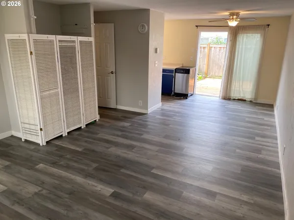 an empty room with wooden floor and windows