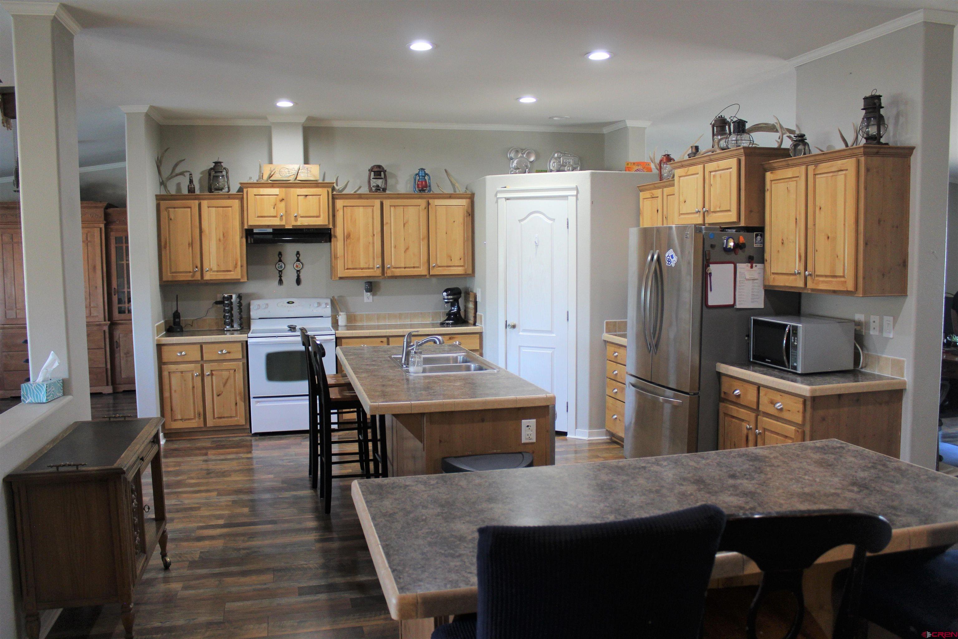 16875 Ember Road Cedaredge, CO 81413 - Photo 13 of 31 a kitchen with stainless steel appliances granite countertop a stove refrigerator and cabinets