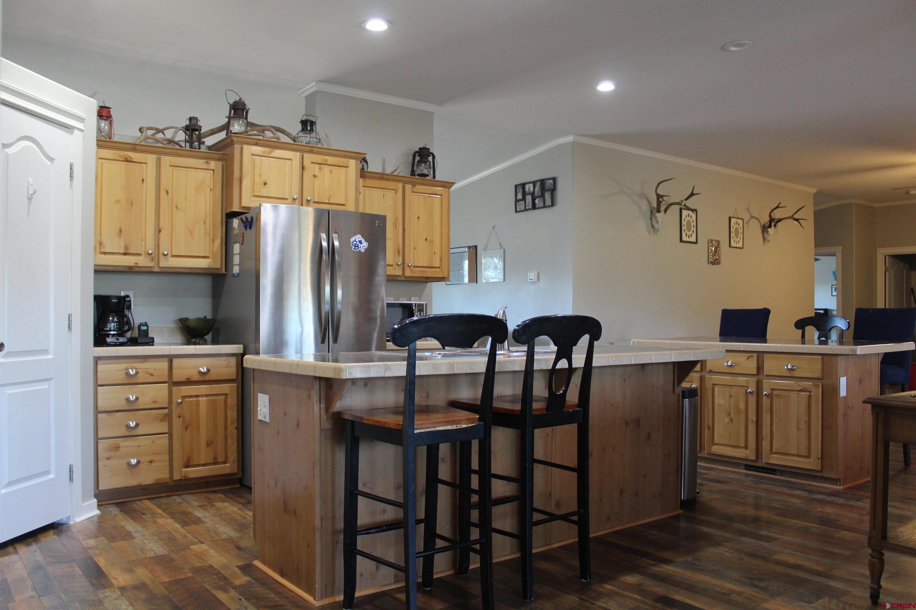 16875 Ember Road Cedaredge, CO 81413 - Photo 14 of 31 a kitchen with stainless steel appliances granite countertop a table chairs refrigerator and sink