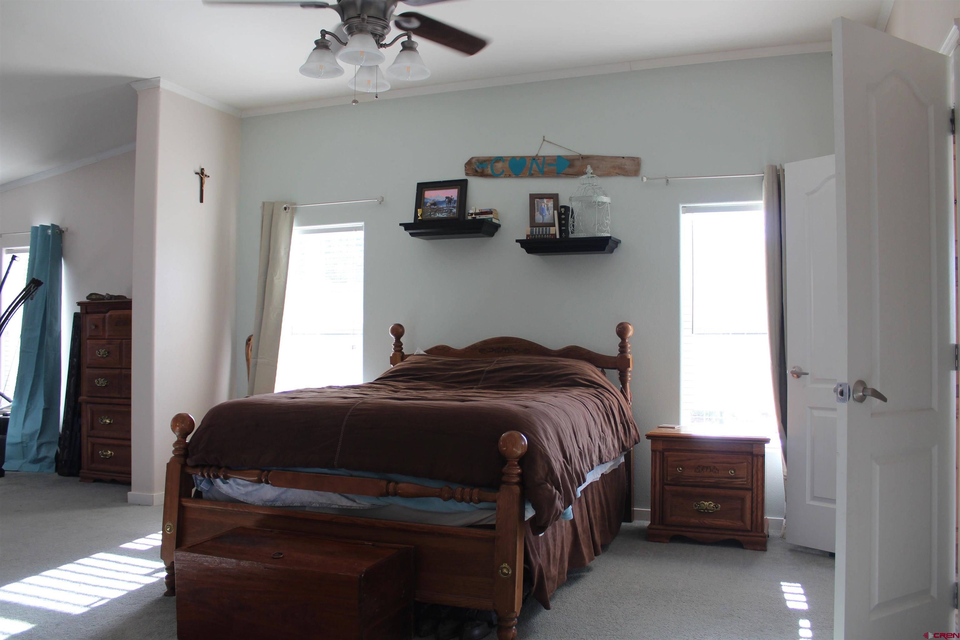 16875 Ember Road Cedaredge, CO 81413 - Photo 16 of 31 a bedroom with a bed and cabinets