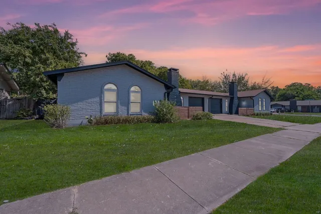 a front view of a house with a garden and yard