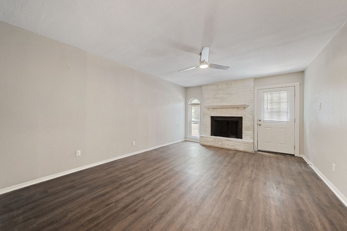 1810 Mearns Meadow Boulevard, Unit A Austin, TX 78758 - Photo 12 of 16 an empty room with wooden floor fireplace and windows