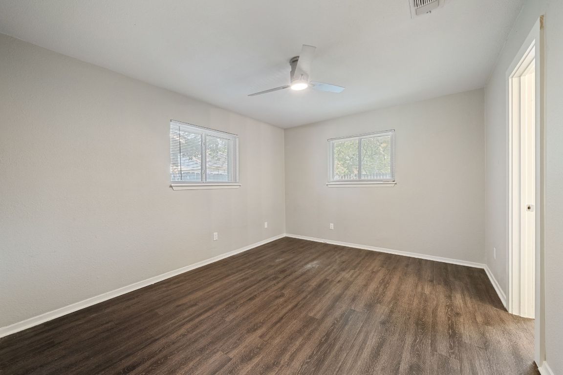 1810 Mearns Meadow Boulevard, Unit A Austin, TX 78758 - Photo 14 of 16 an empty room with wooden floor and windows