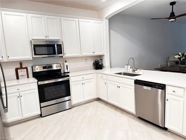 a kitchen with white cabinets and white appliances