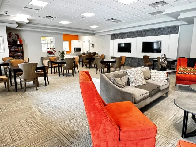 a living room with furniture kitchen view and a large window