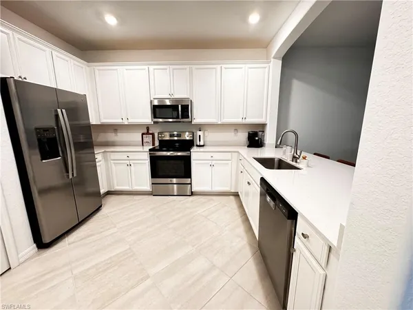 a kitchen with stainless steel appliances a refrigerator stove microwave and sink