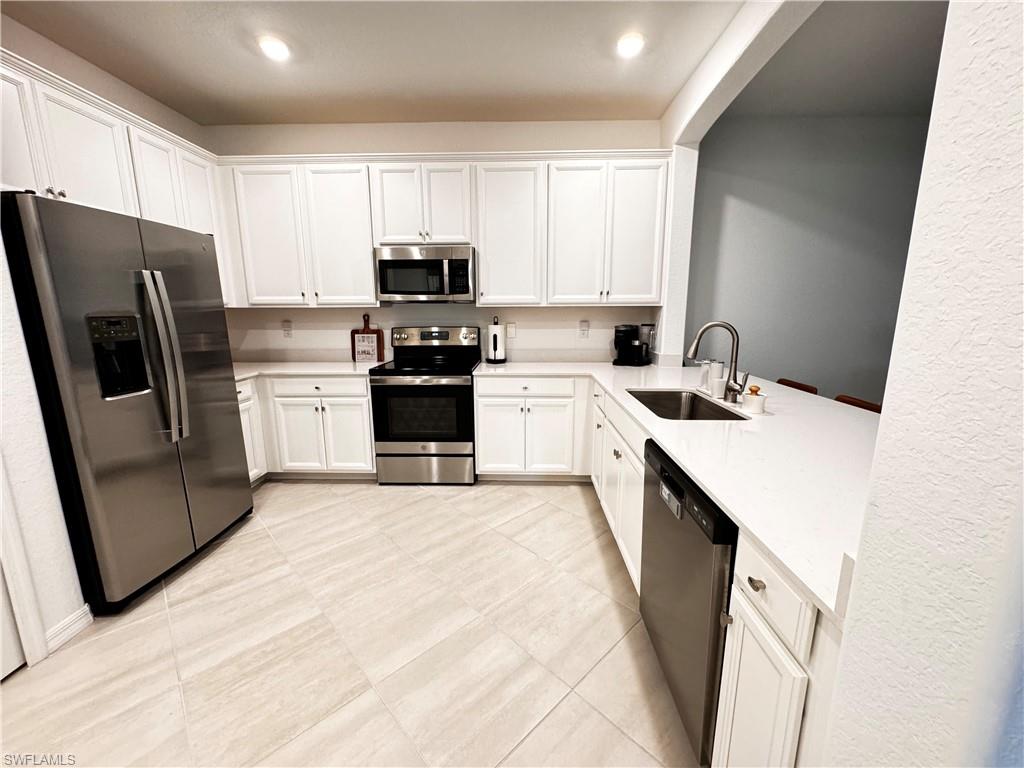 2084 Wellington Street Naples, FL 34120 - Photo 2 of 23 a kitchen with stainless steel appliances a refrigerator stove microwave and sink