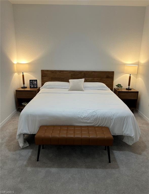 2084 Wellington Street Naples, FL 34120 - Photo 9 of 23 a bedroom with a bed and a lamp