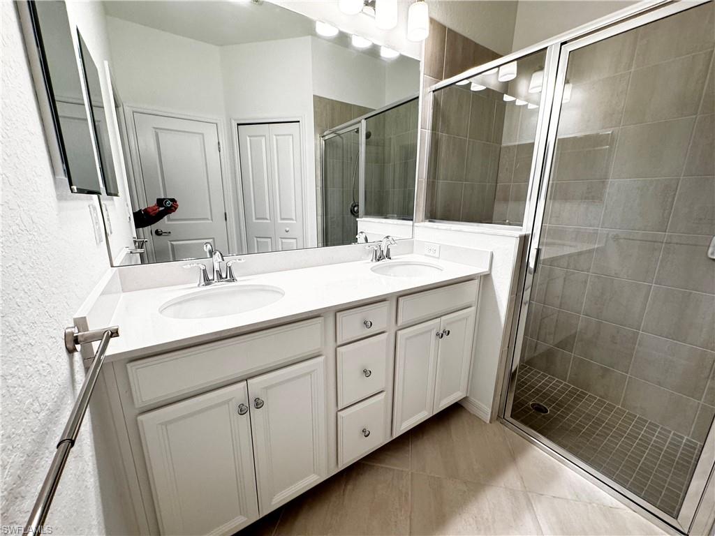2084 Wellington Street Naples, FL 34120 - Photo 10 of 23 a bathroom with a double vanity sink and mirror