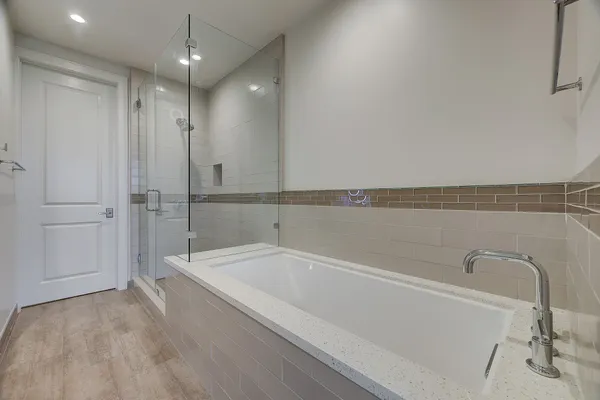a large spacious bathroom with a large tub sink shower and a mirror