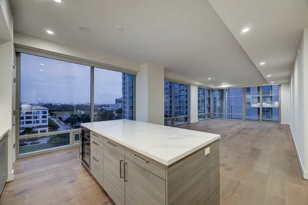 a large white kitchen with a large window and refrigerator