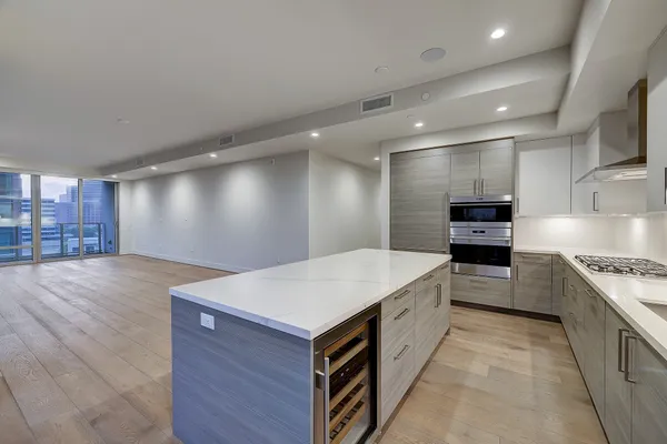 a living room with stainless steel appliances kitchen island granite countertop furniture wooden floor and view kitchen