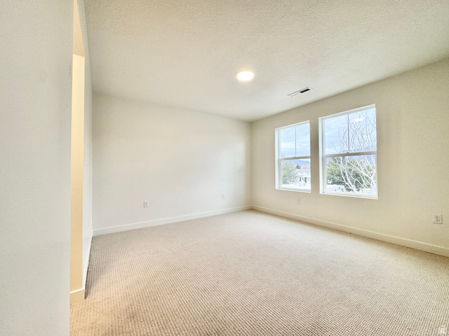 1650 North Main Street Layton, UT 84041 - Photo 15 of 24 Spacious room featuring neutral carpeting, two large windows, a recessed ceiling light, and white baseboards