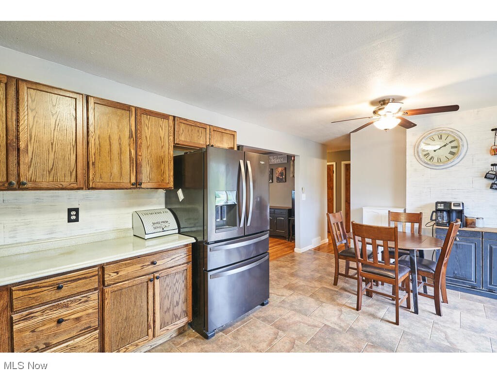 11530 Girdled Road Painesville, OH 44077 - Photo 6 of 32 Kitchen featuring stainless steel fridge with ice dispenser, a textured ceiling, light tile floors, and ceiling fan
