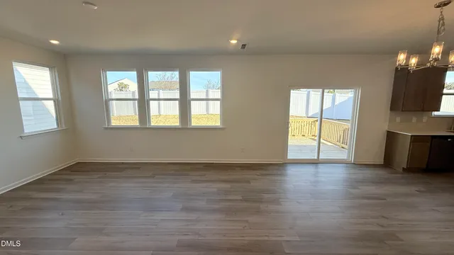 wooden floor in an empty room with a kitchen