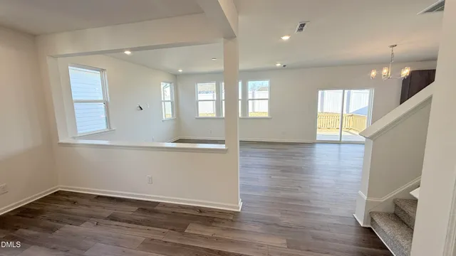 a view of a kitchen with kitchen island wooden floor center island and stainless steel appliances
