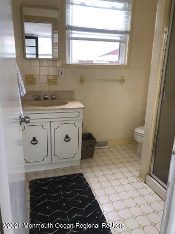 204 4th Avenue Bradley Beach, NJ 07720 - Photo 10 of 24 a bathroom with a sink a toilet and a mirror