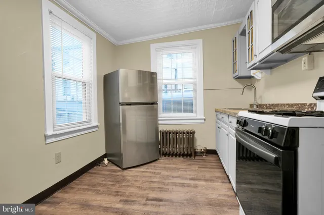 a kitchen with a stove a refrigerator and a window