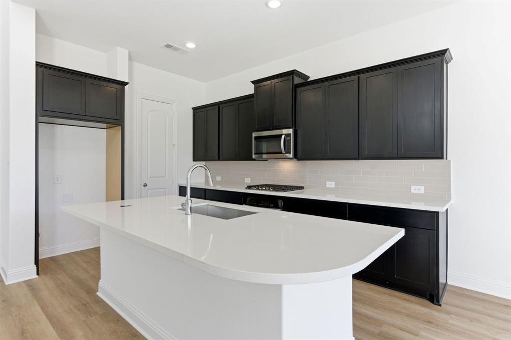 241 Bay Laurel Road McKinney, TX 75071 - Photo 11 of 32 a kitchen with stainless steel appliances a microwave a sink and a refrigerator